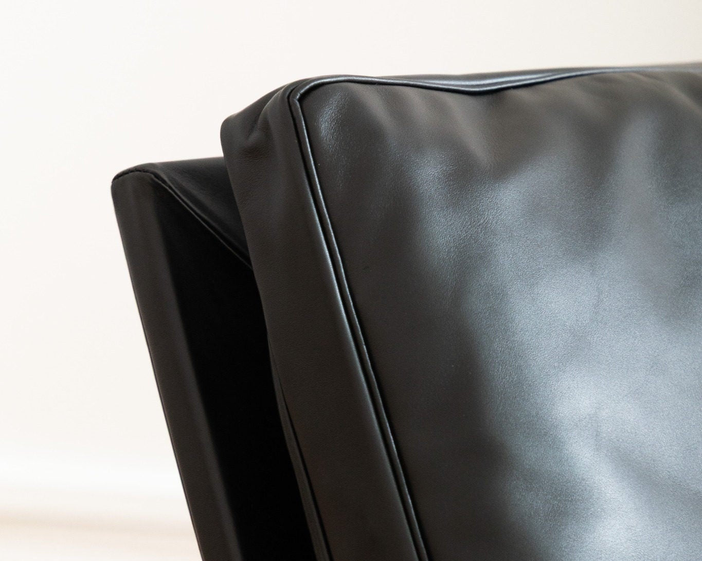 Détail du dossier en cuir noir du fauteuil FK 6720 Easy Chair, couture parfaite, ligne tendue et design fonctionnel, Lange Production, Fabricius & Kastholm