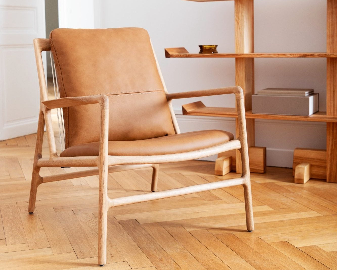 fauteuil dedo easy chair de gazzda exposé chez longitude marseille en chêne assise en cuir