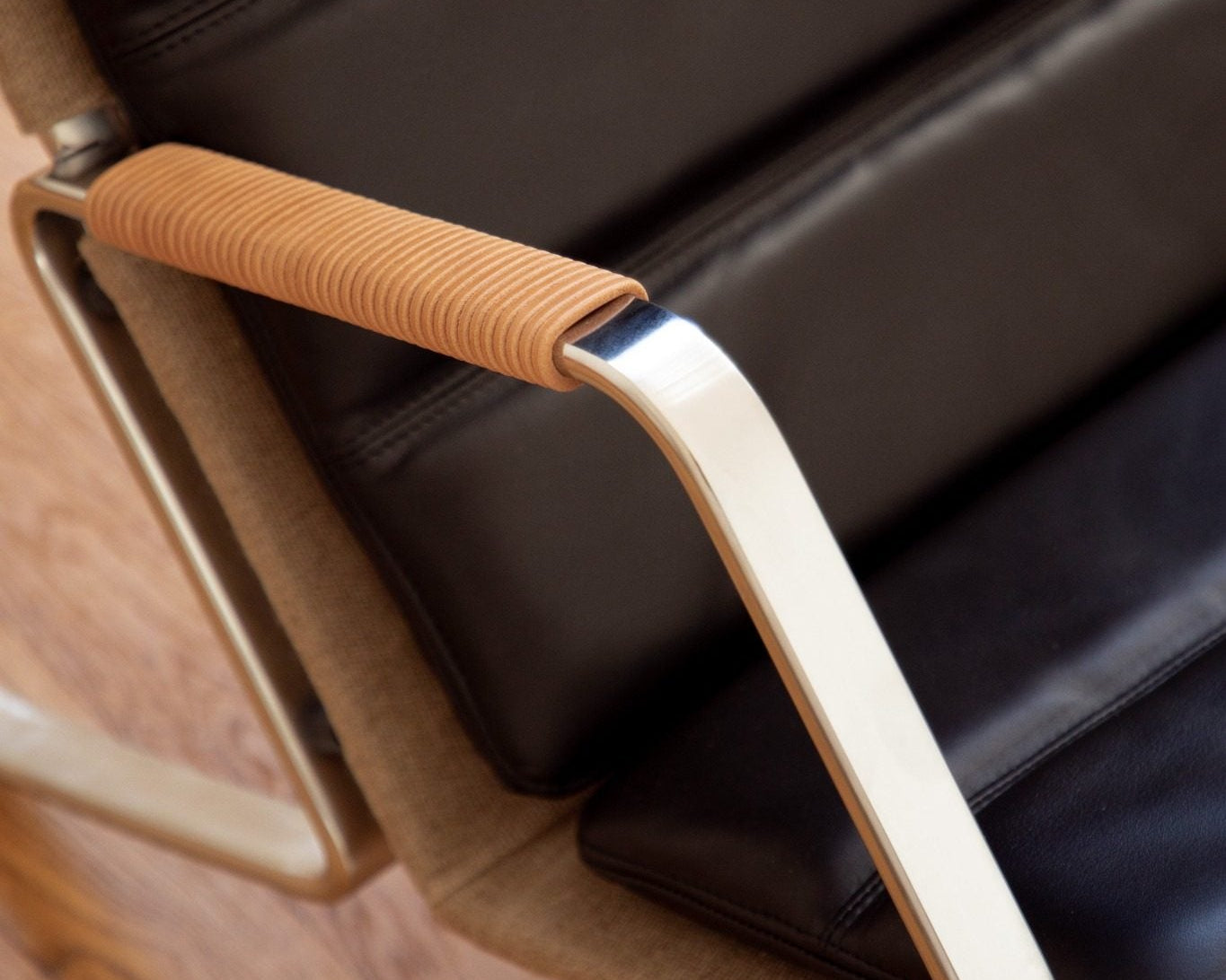 Fauteuil FK87 Grasshopper en cuir noir, accoudoir acier brossé et cuir, réédition Lange Production, design Fabricius & Kastholm, visible chez Longitude Marseille