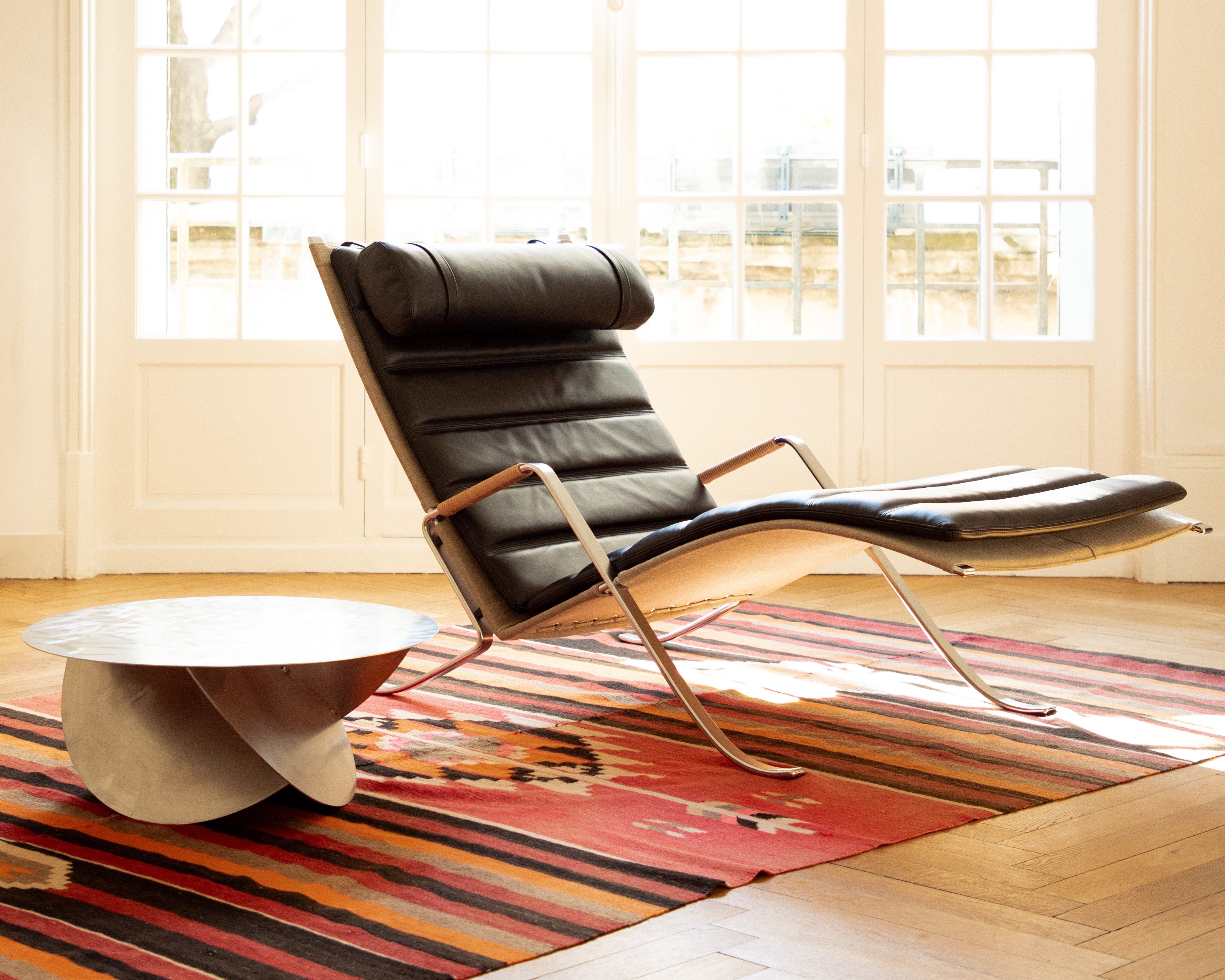 Fauteuil FK87 Grasshopper en cuir, réédition Lange Production, design Fabricius & Kastholm, visible chez Longitude Marseille avec table Sphere de Julien Le Goff, artisan designer, acier inox