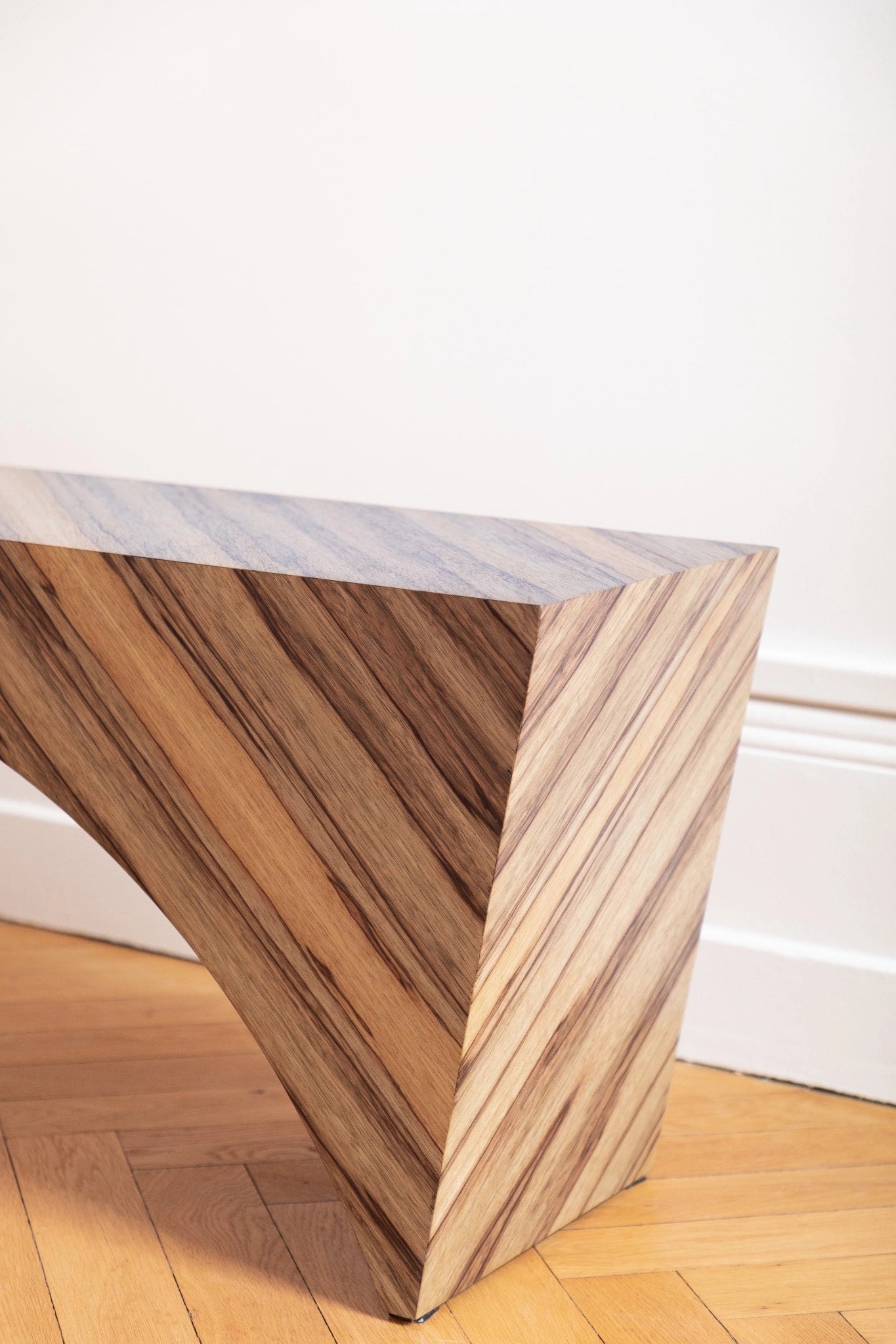 PONDI : banc aux lignes tendues et placage en fraké bariolé, sobriété contemporaine et mémoire artisanale.