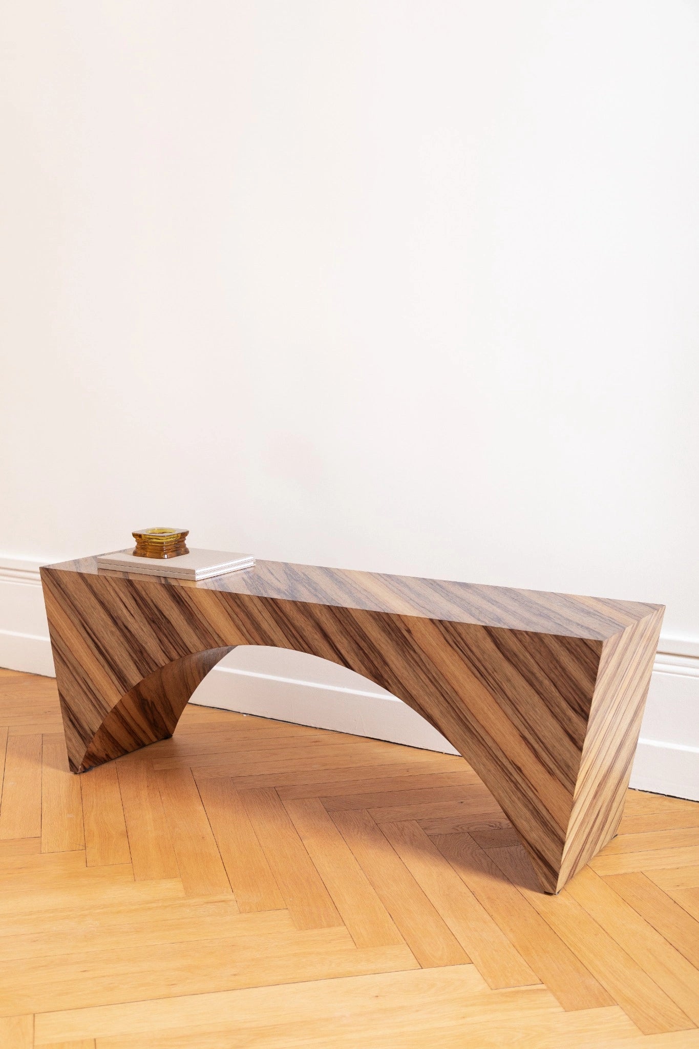 PONDI : banc aux lignes tendues et placage en fraké bariolé, sobriété contemporaine et mémoire artisanale.