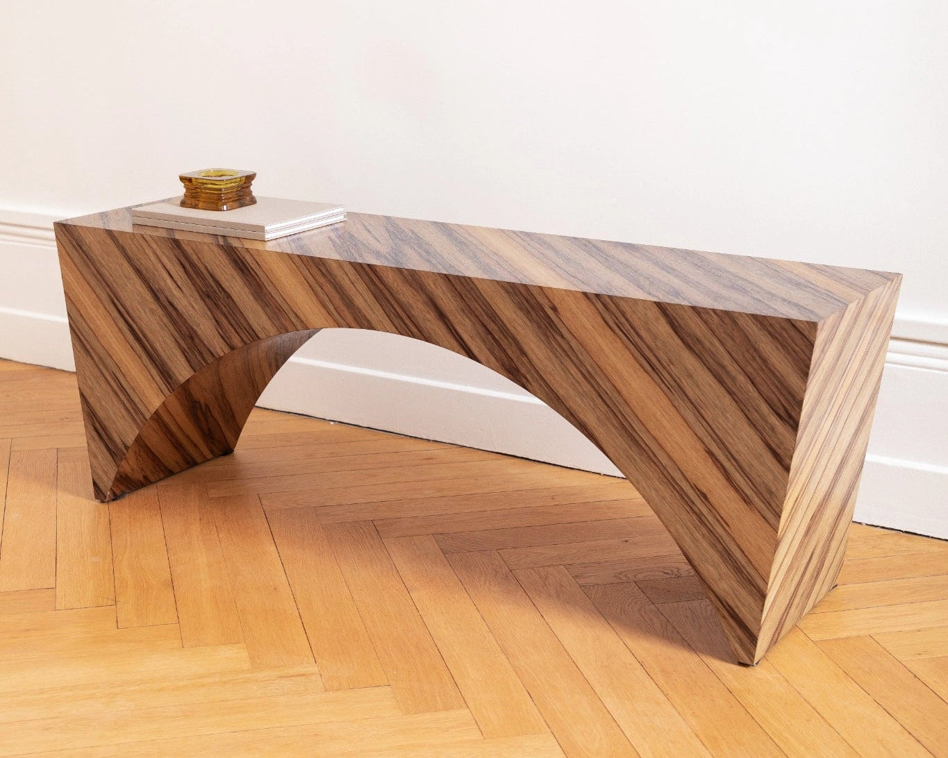 PONDI : banc aux lignes tendues et placage en fraké bariolé, sobriété contemporaine et mémoire artisanale.