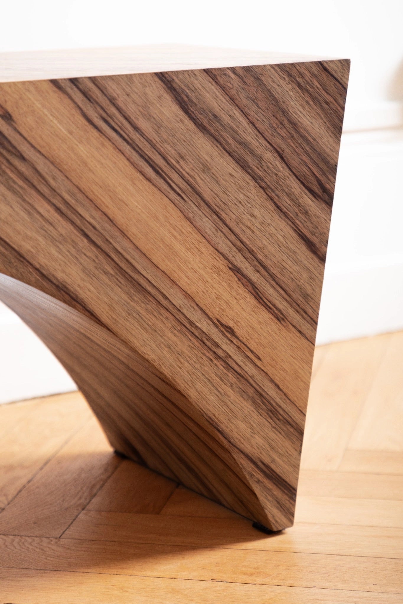 PONDI : banc aux lignes tendues et placage en fraké bariolé, sobriété contemporaine et mémoire artisanale.