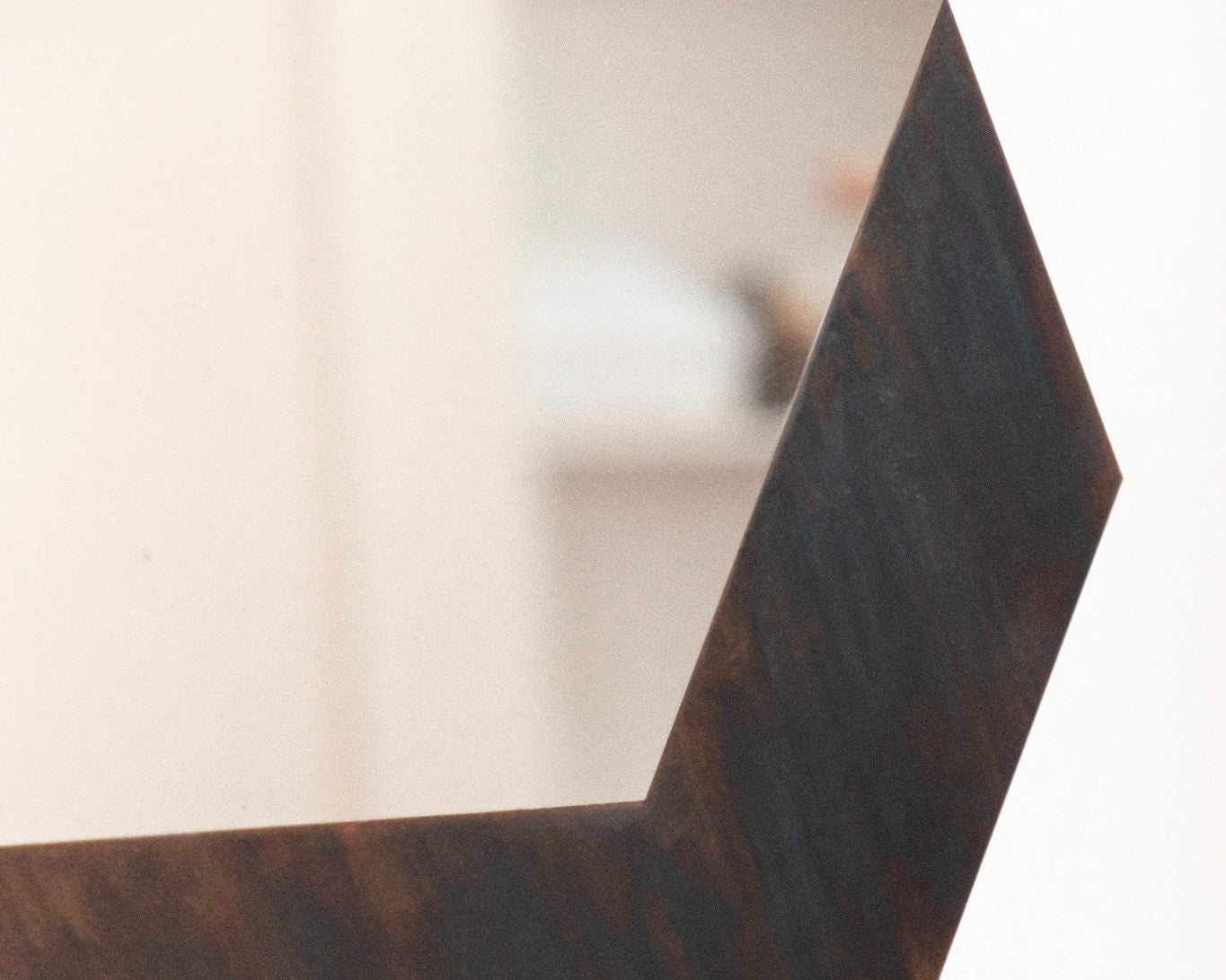 Miroir graff par julien le goff artisan designer, miroir sculptural en acier inox poli miroir avec oxydation en bordure expose chez longitude interior design à marseille vue d'un angle de la bordure oxydation