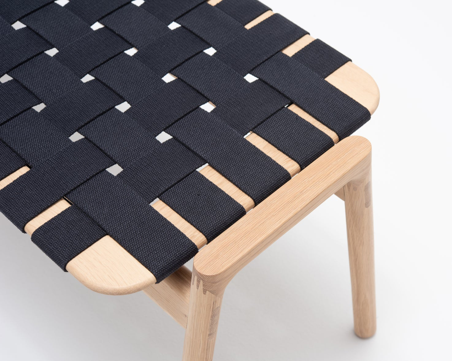Banc KLUPA par Gazzda en chêne, assise en coton zoom sur le tissage noir référencé chez LONGITUDE à Marseille et à distance