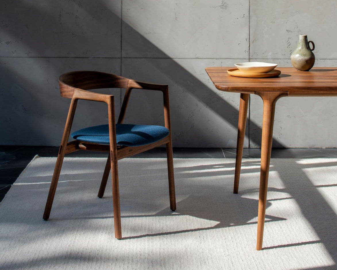 muna chair de gazzda en noyer assisse en textile bleu devant table fawn en noyer référencé par longitude marseille