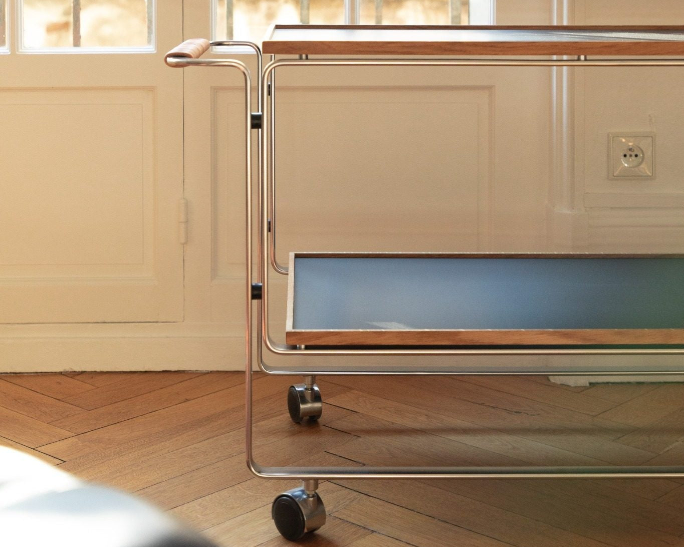 Chariot bar HB 128 par Horst Brüning, structure en acier chromé et plateaux en bois, design moderniste édité par Lange Production, présenté par Longitude Interior Design à Marseille. profil salon