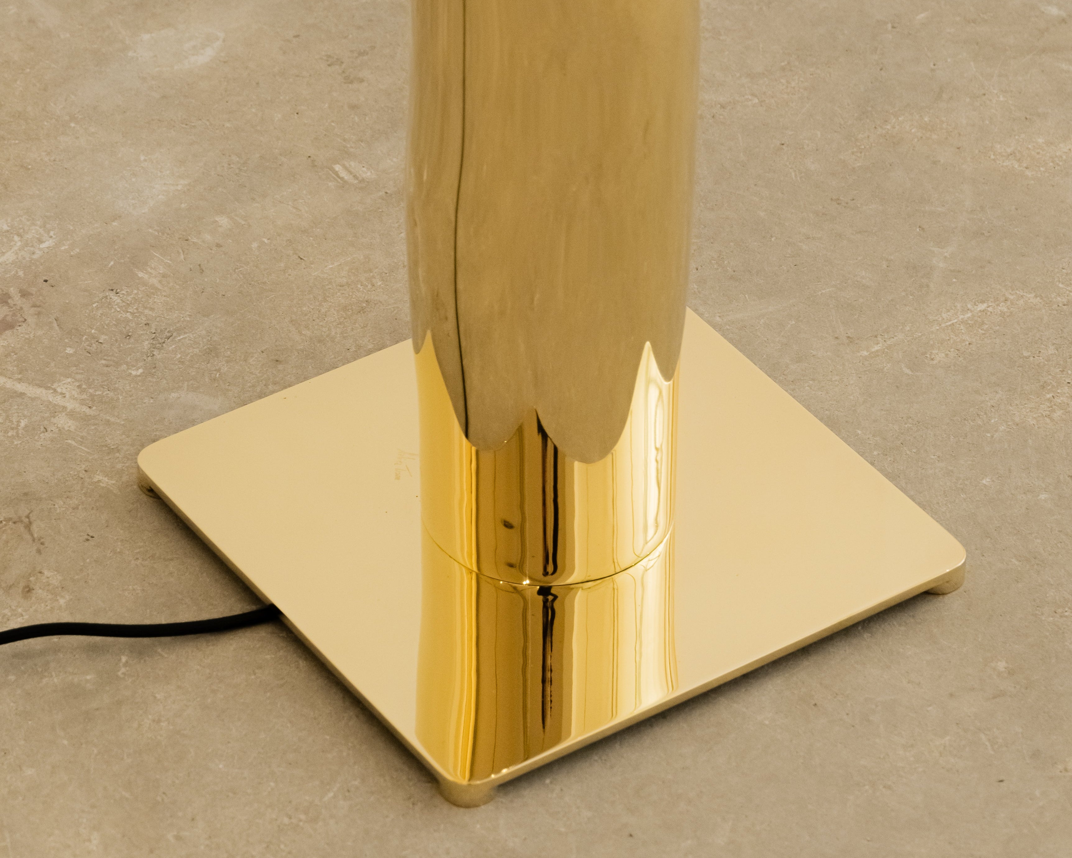 Détail du lampadaire helios façonné à la main en laiton poli miroir par victor tison Le socle et le lancement de la colonne Exemplaire signé sur la base