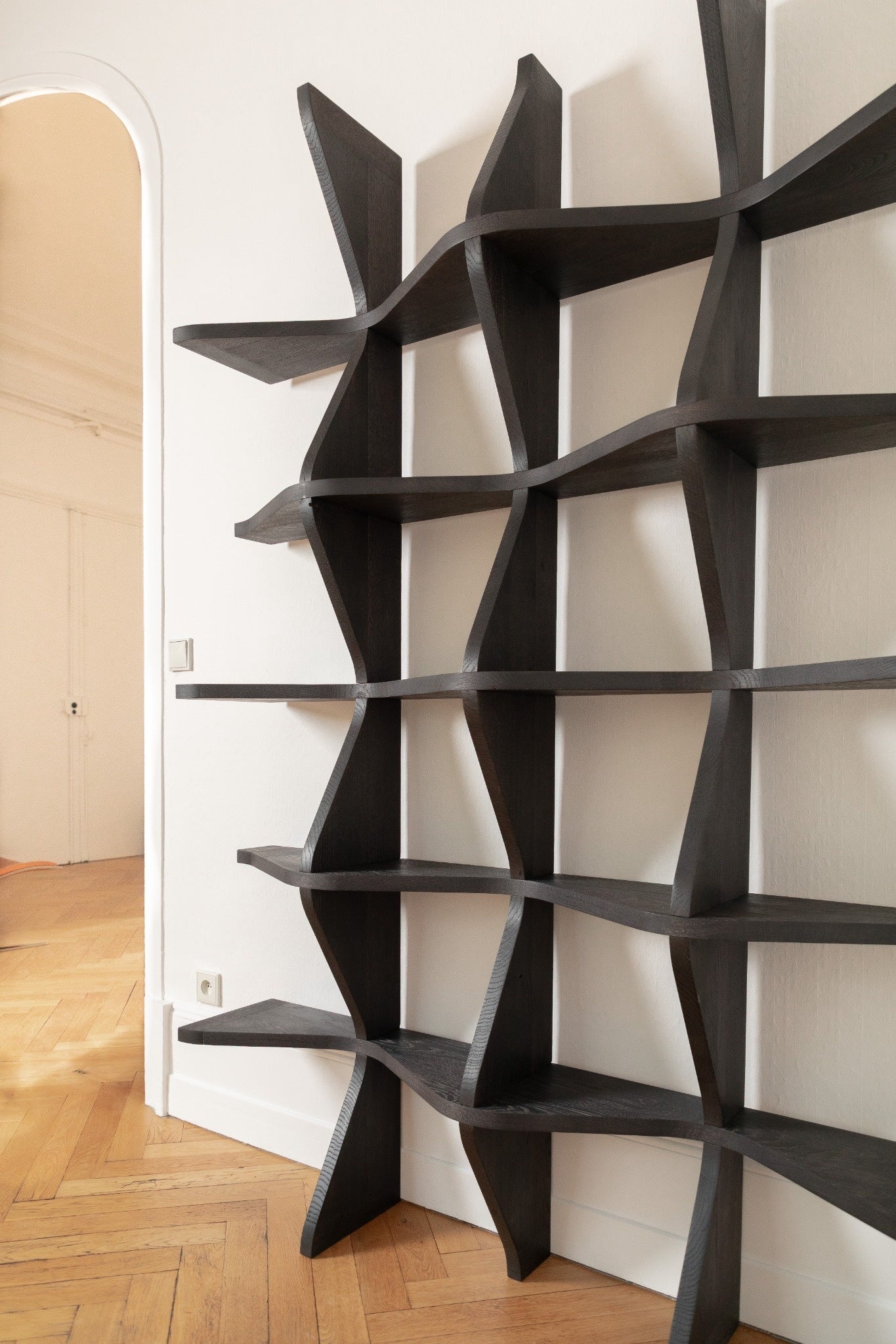 VAGUE : bibliothèque sculpturale en chêne, aux lignes ondulées, entre savoir-faire artisanal et design contemporain.