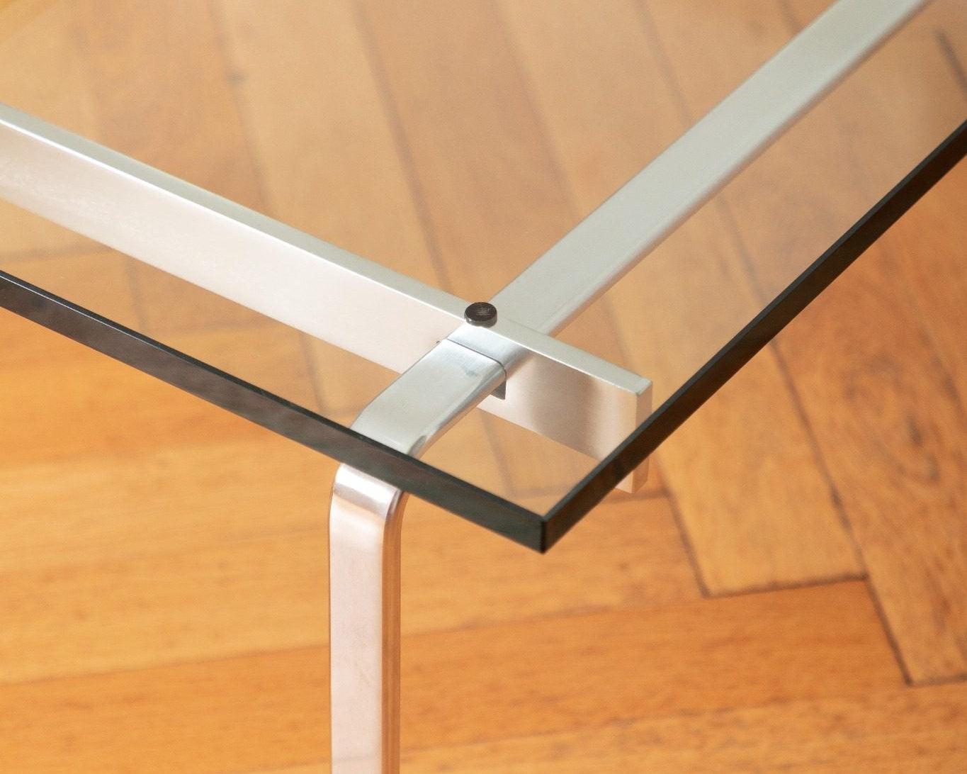 Table basse FK 89 en acier chromé et verre transparent, design Fabricius & Kastholm, éditée par Lange Production, présentée au showroom Longitude à Marseille. Angle et structure