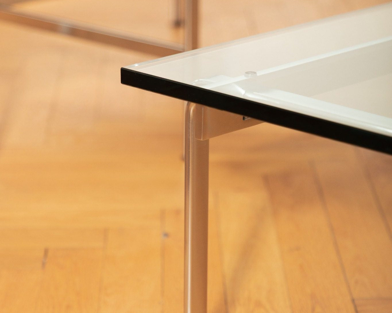 Table basse FK 89 en acier chromé et verre transparent, design Fabricius & Kastholm, éditée par Lange Production, présentée au showroom Longitude à Marseille. zoom pied 